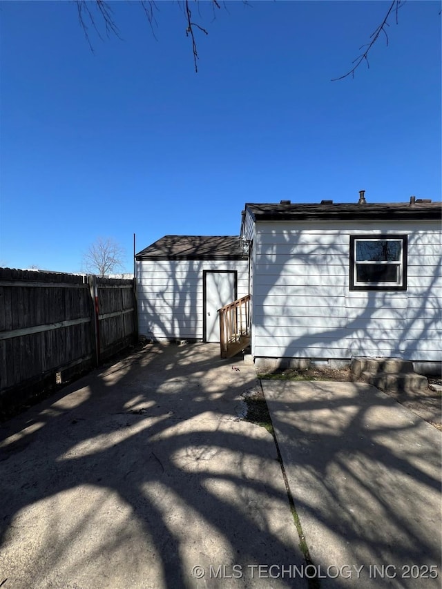 rear view of property featuring fence and a patio