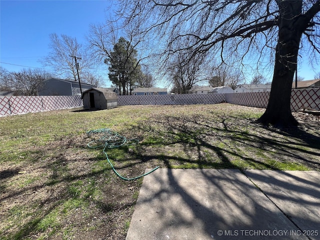 view of yard featuring a storage unit, an outdoor structure, and a fenced backyard