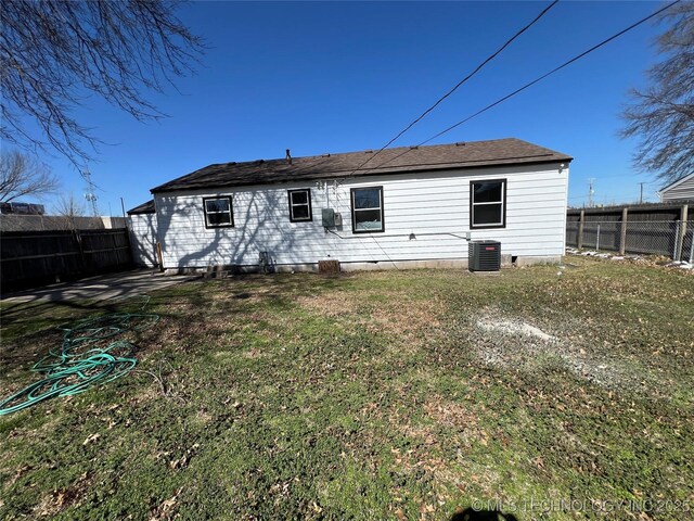 back of house with a yard, a fenced backyard, and cooling unit