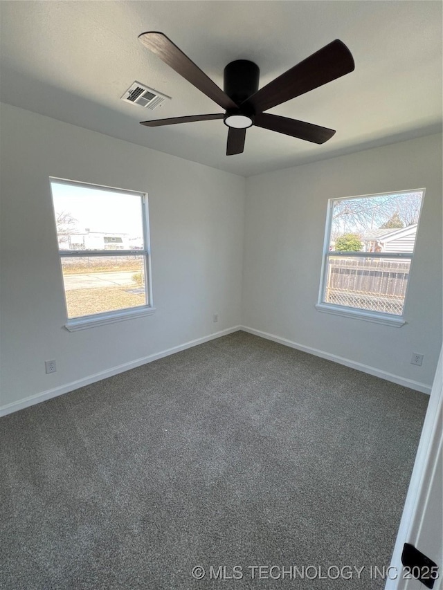 unfurnished room featuring carpet, plenty of natural light, visible vents, and baseboards