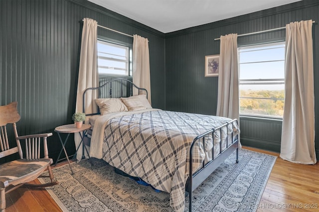 bedroom with multiple windows and hardwood / wood-style floors