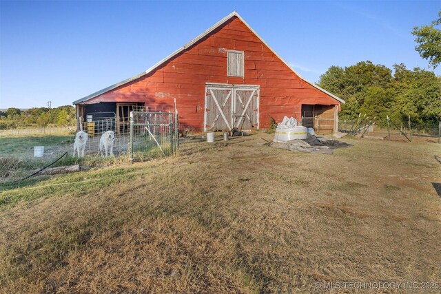 view of barn featuring fence