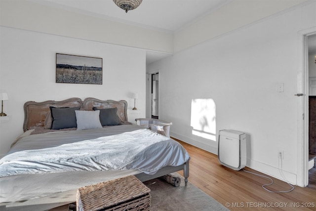 bedroom featuring baseboards and wood finished floors