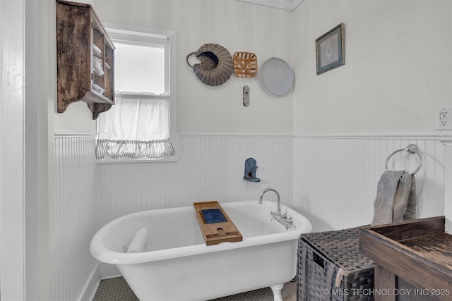 bathroom with a freestanding tub and wainscoting