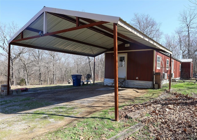 view of parking / parking lot with a detached carport and dirt driveway