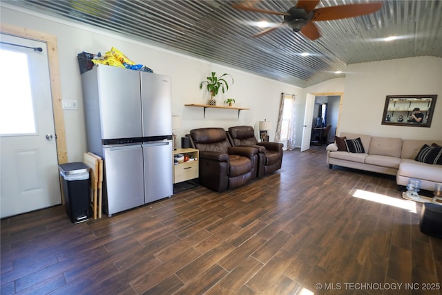 living area with dark wood finished floors, vaulted ceiling, and a ceiling fan