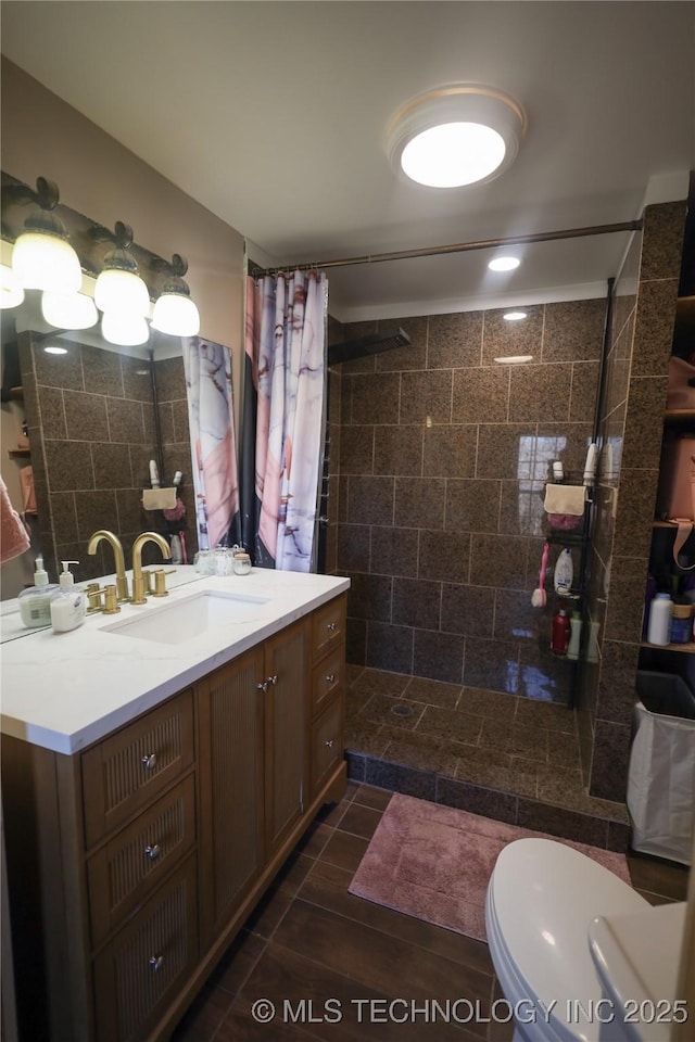 full bathroom with tiled shower, toilet, and vanity