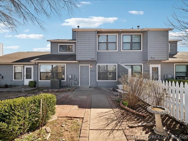 back of property featuring central AC, a patio area, and fence