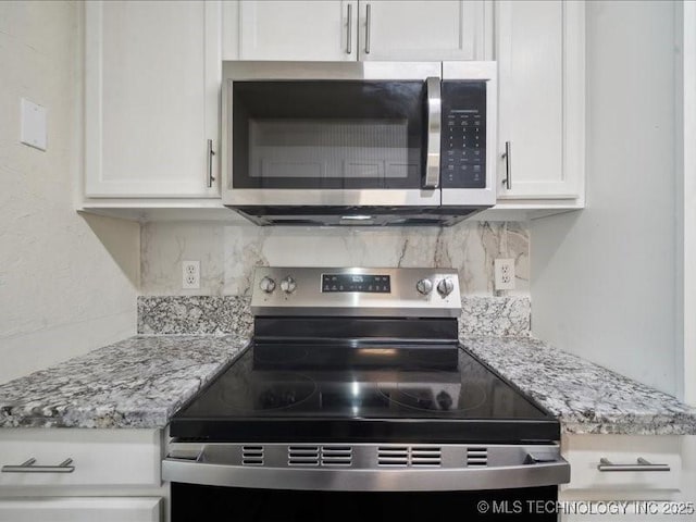 kitchen with light stone countertops, white cabinetry, tasteful backsplash, and appliances with stainless steel finishes