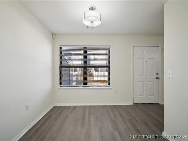 unfurnished dining area featuring baseboards and wood finished floors