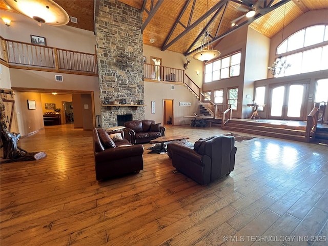 living room with hardwood / wood-style flooring, wood ceiling, stairs, a fireplace, and a wealth of natural light