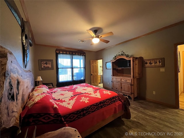 bedroom featuring wood finished floors, visible vents, baseboards, ornamental molding, and ensuite bath