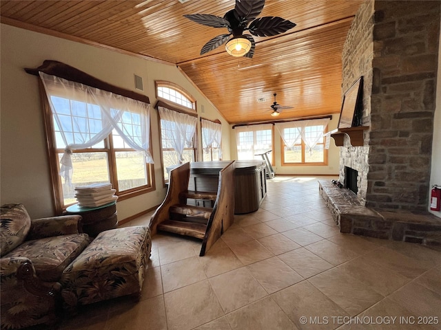 living room with lofted ceiling, plenty of natural light, wood ceiling, and a stone fireplace