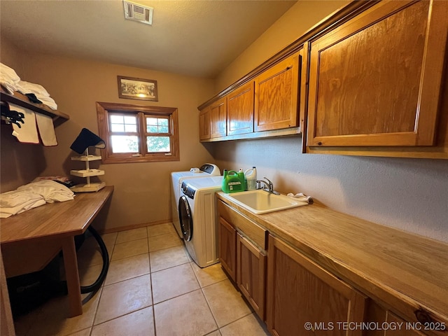 laundry area with light tile patterned floors, a sink, visible vents, cabinet space, and washing machine and clothes dryer