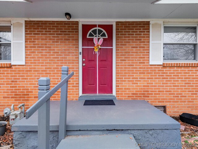 property entrance with brick siding and crawl space