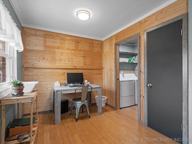 office space with light wood finished floors, washer and clothes dryer, crown molding, and wood walls