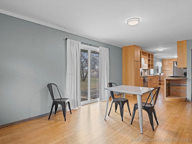 dining space with light wood finished floors and baseboards