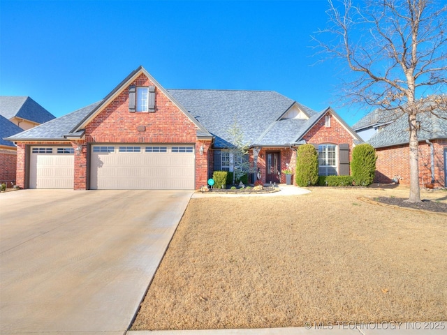 traditional-style home featuring concrete driveway, a garage, brick siding, and roof with shingles