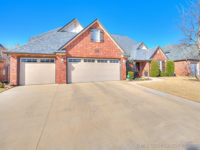 traditional home with a garage, brick siding, roof with shingles, and concrete driveway