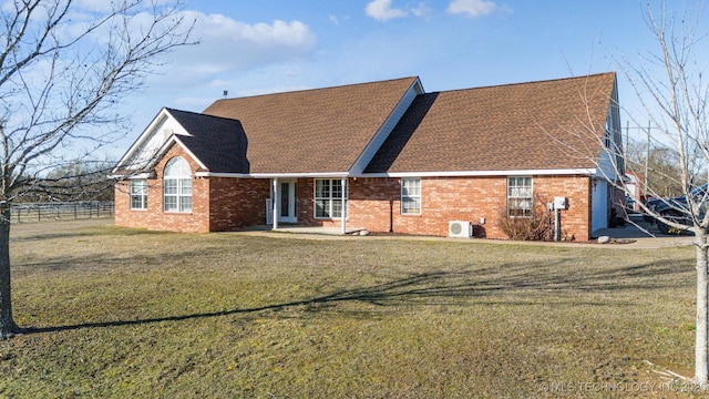 back of house with ac unit, brick siding, a lawn, and a shingled roof