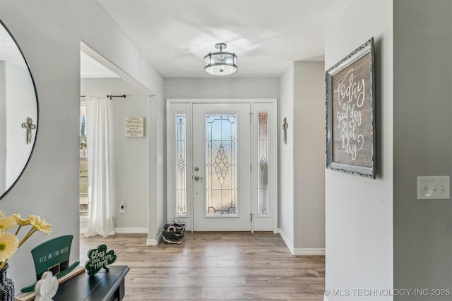 foyer entrance with baseboards and wood finished floors