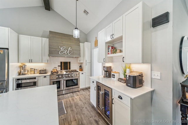 kitchen with custom exhaust hood, stainless steel appliances, light countertops, visible vents, and beverage cooler