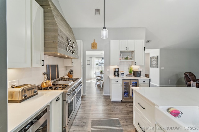 kitchen featuring visible vents, white cabinets, wine cooler, wood finished floors, and double oven range