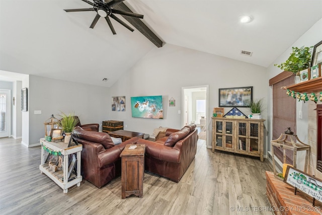 living area featuring visible vents, baseboards, a ceiling fan, light wood-style flooring, and beam ceiling