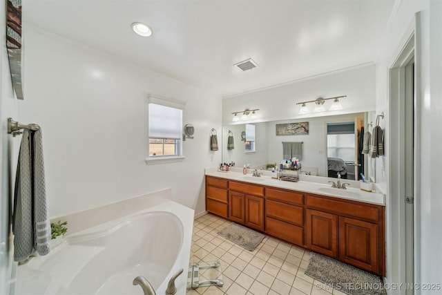 ensuite bathroom featuring a garden tub, connected bathroom, a sink, visible vents, and tile patterned floors