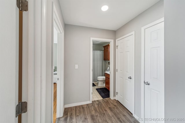 hall with wood finished floors and baseboards