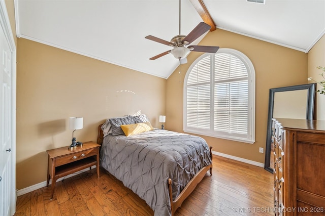 bedroom featuring vaulted ceiling with beams, ceiling fan, light wood-style flooring, and baseboards