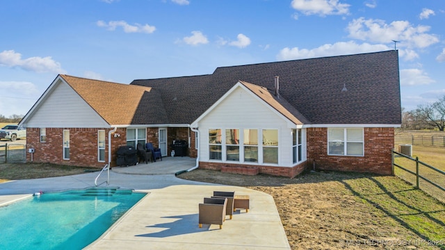 back of house with central AC unit, a patio area, fence, and brick siding