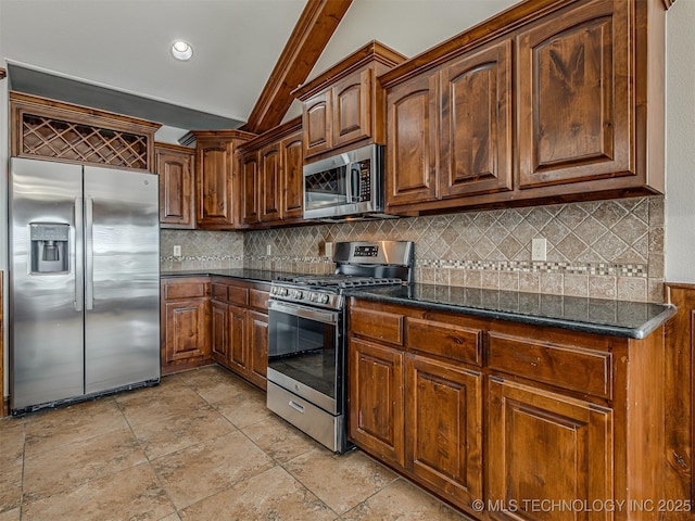 kitchen featuring backsplash, appliances with stainless steel finishes, dark stone counters, and vaulted ceiling