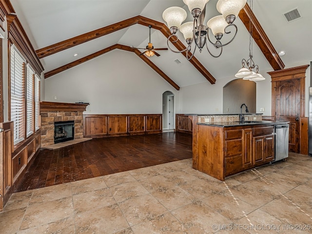 kitchen with visible vents, a sink, open floor plan, ceiling fan with notable chandelier, and stainless steel dishwasher