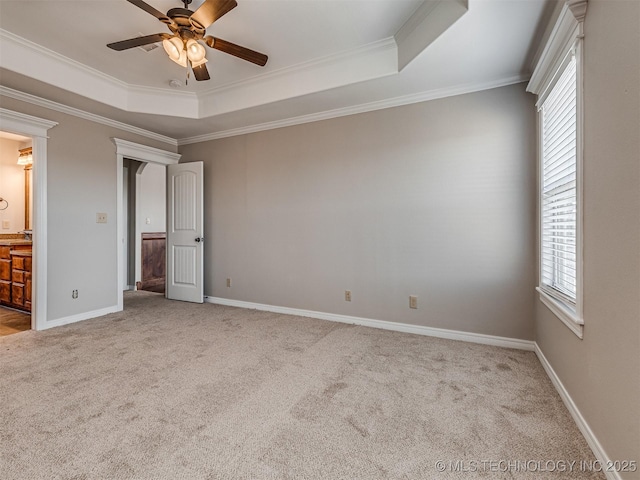 unfurnished bedroom featuring baseboards, a raised ceiling, ornamental molding, and carpet flooring