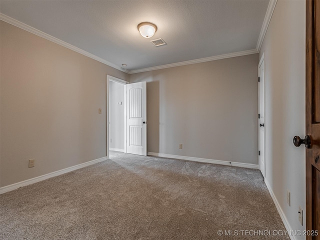 empty room featuring baseboards, visible vents, carpet floors, and ornamental molding