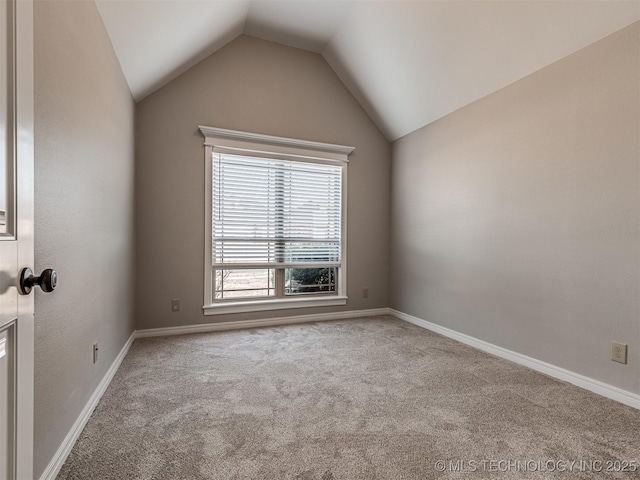 unfurnished room with baseboards, lofted ceiling, and carpet flooring