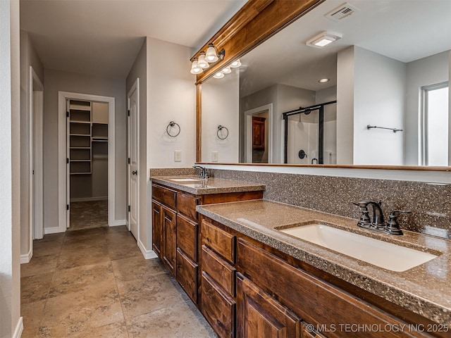 bathroom with double vanity, visible vents, a shower stall, and a sink