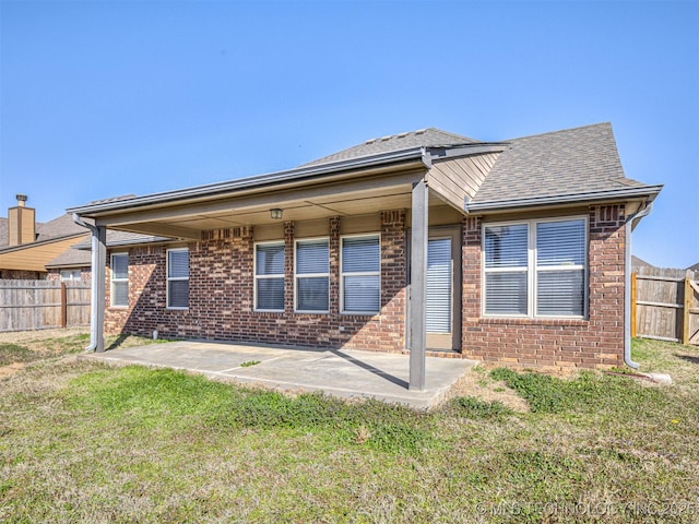 rear view of property with a yard, a patio, and a fenced backyard