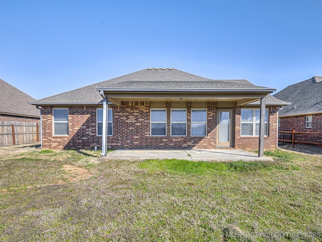 rear view of property featuring a patio, a yard, a fenced backyard, and brick siding