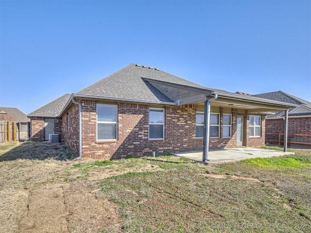 rear view of property featuring a patio, a fenced backyard, and brick siding