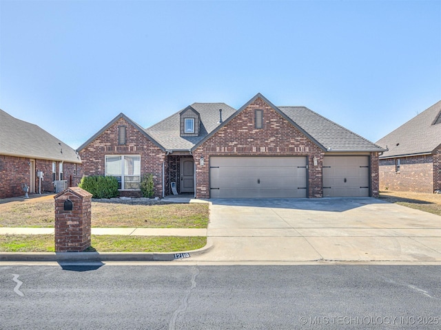 traditional-style house with a garage, brick siding, concrete driveway, and a shingled roof