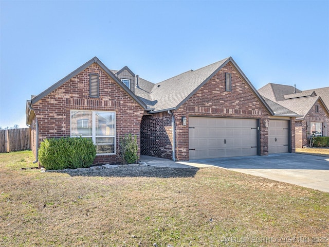 view of front of home featuring driveway, a front lawn, fence, a garage, and brick siding