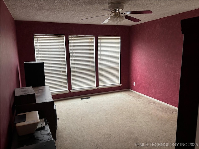 spare room with a textured ceiling, ceiling fan, plenty of natural light, and carpet flooring