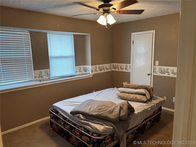 bedroom featuring a textured ceiling, carpet flooring, a ceiling fan, and baseboards