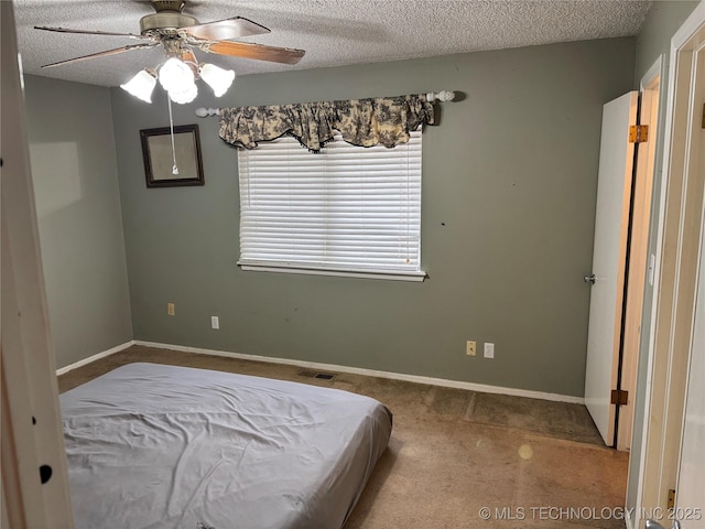 carpeted bedroom featuring a textured ceiling, visible vents, and baseboards