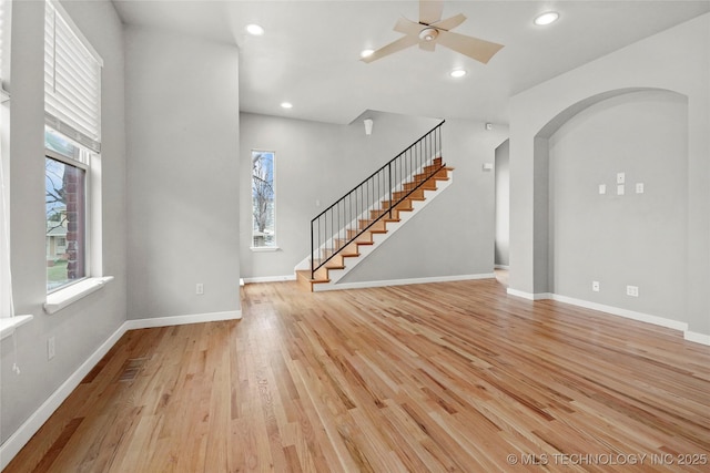 unfurnished living room with light wood-style flooring, baseboards, a wealth of natural light, and recessed lighting