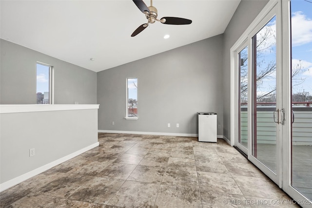 empty room with vaulted ceiling, baseboards, and ceiling fan