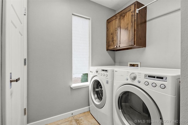 washroom featuring baseboards, cabinet space, and washer and dryer