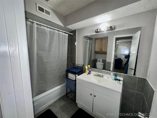 full bathroom featuring visible vents, shower / tub combo with curtain, tile patterned flooring, a textured ceiling, and vanity